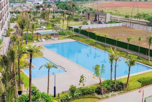 - une vue sur la piscine bordée de palmiers dans l'établissement Sky House BSD Studio by Shinzhouz, à Tjilandak