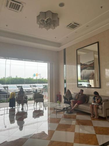 a group of people sitting on a couch in a lobby at Sky House BSD Studio by Shinzhouz in Cilandak