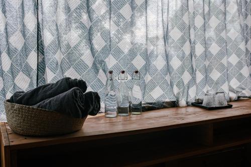 dos botellas de vidrio sentadas en una mesa de madera en Stella Mộc Châu Homestay, en Mộc Châu