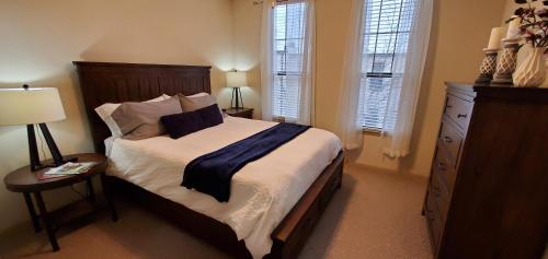 1 dormitorio con 1 cama, vestidor y ventanas en Old Fort Loft King & Queen suites nearest accomodation to Marshals Museum power your EV for free! en Fort Smith