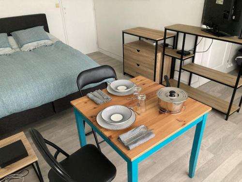 une pièce avec une table et un lit et une table et des chaises dans l'établissement Grand studio confort Evreux, à Évreux