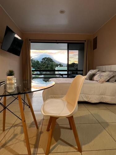 um quarto com uma mesa de vidro e uma cama com vista em Volcánico em La Fortuna