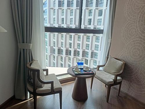 een kamer met een tafel en twee stoelen en een groot raam bij Luxury APEC MANDALA MŨI NÉ SG HAPPY HOUSE in Ấp Thiẹn Ái