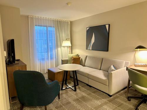 a living room with a couch and a table at Staybridge Suites Milwaukee West-Oconomowoc by IHG in Oconomowoc