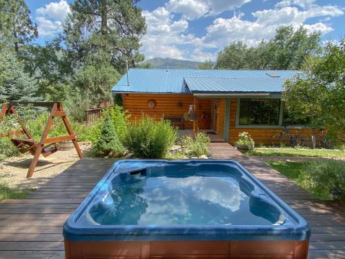 a hot tub on a deck in front of a cabin at Country Sunshine Bed and Breakfast in Durango