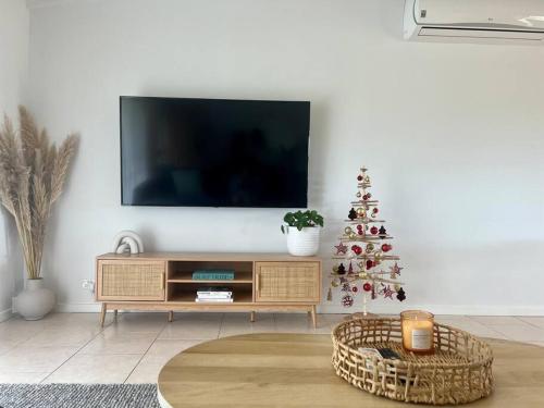 a living room with a television and a christmas tree at Cosy Beach House - Near Hot Springs. in Tootgarook