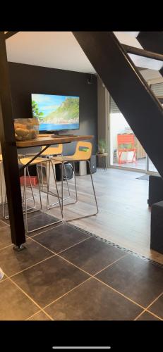 a living room with a table and a television at Lepadaloft in Villeneuve-Saint-Georges