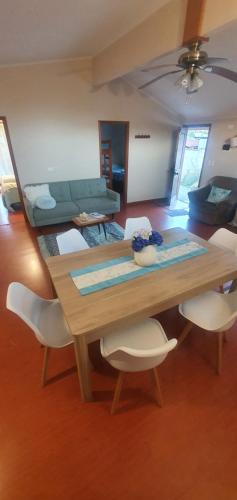 ニエブラにあるCasa en Niebla Valdiviaのリビングルーム(木製テーブル、白い椅子付)