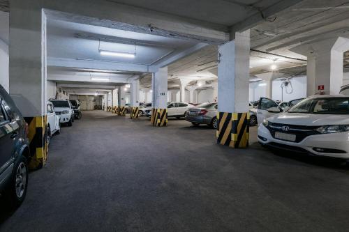 uma garagem cheia de carros estacionados em Lofts Charmosos Palácio Quitandinha com Garagem em Petrópolis