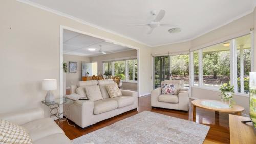 a living room with a couch and a table at Kooringal Cottage - Home By The Sea in Woorim