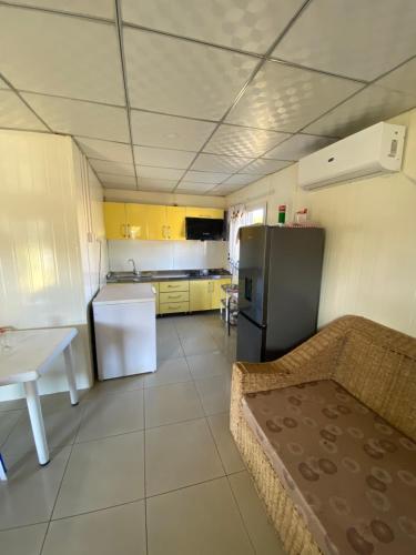 eine kleine Küche mit einem Sofa und einem Kühlschrank in der Unterkunft Golden Horizon in Lopes