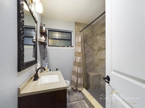 a bathroom with a sink and a shower at The Cozy and Comfy FLEX Renovated Mid Century Modern 3BR 2B Heart of The City 3 Mins to JU 5 Mins to Downtown 10 Mins Jax Cruise 15 Mins to Beach 15 Mins to MAYO Clinic in Jacksonville