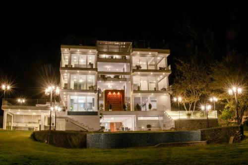 een groot wit gebouw 's nachts met verlichting bij CASONA LA MARQUEZA - Hotel Boutique in Tinquipaya