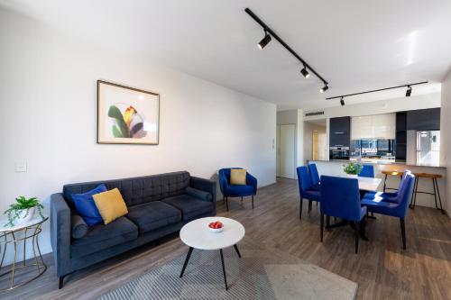 a living room with a couch and a table at Arena Apartments by CLLIX in Brisbane