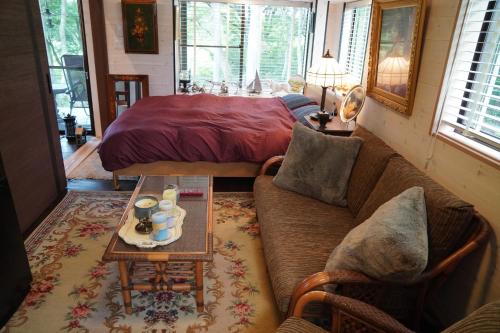a living room with a couch and a bed at POND CABIN Myoko - Vacation STAY 15921 in Myoko