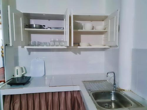 a kitchen with white cabinets and a sink at Star house old town lanta in Ko Lanta