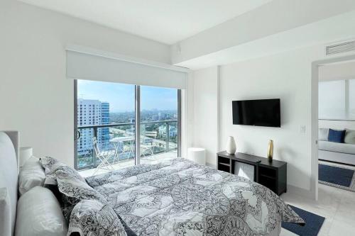um quarto branco com uma cama e uma grande janela em New 1/1 Apartment in Smart Brickell with Parking em Miami