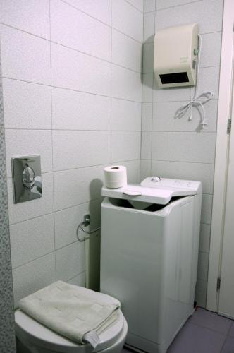 a white bathroom with a toilet and a sink at Eleni Boutique Apartment in Lindos