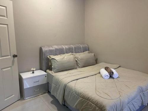 um pequeno quarto com uma cama com duas almofadas em Four Rooms Homstay 'A' With Wifi And Smart TV in Wakaf Tapai 