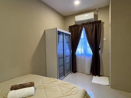 um quarto com uma cama e uma grande janela em Four Rooms Homstay 'A' With Wifi And Smart TV in Wakaf Tapai 