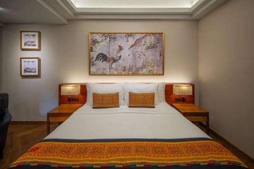 a bedroom with a bed with a painting on the wall at Chala Number6 in Chiang Mai