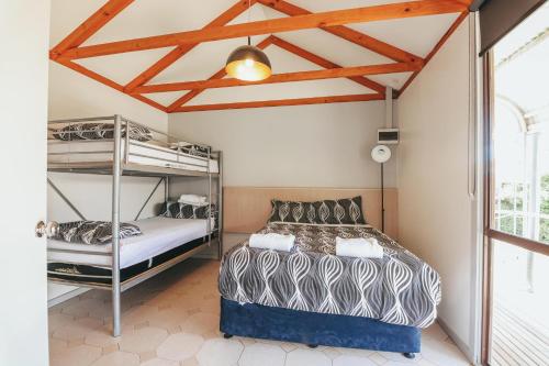 1 Schlafzimmer mit 2 Etagenbetten und einem Fenster in der Unterkunft Eaglehawk Park Canberra in Canberra