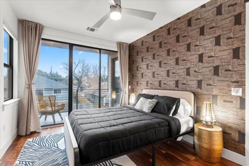 1 dormitorio con cama y pared de ladrillo en 4 Bedroom-Downtown-Rooftop W Views & Walkable en Austin