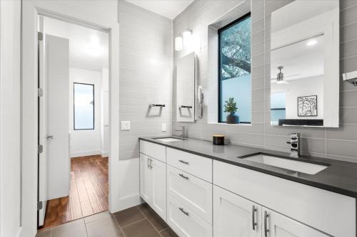 een witte badkamer met een wastafel en een raam bij 4 Bedroom-Downtown-Rooftop W Views & Walkable in Austin