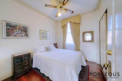 a bedroom with a white bed and a ceiling fan at A peaceful room in Northbridge with free parking in Perth