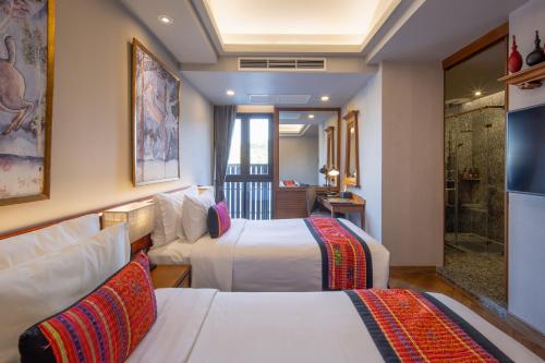 a hotel room with two beds and a couch at Chala Number6 in Chiang Mai