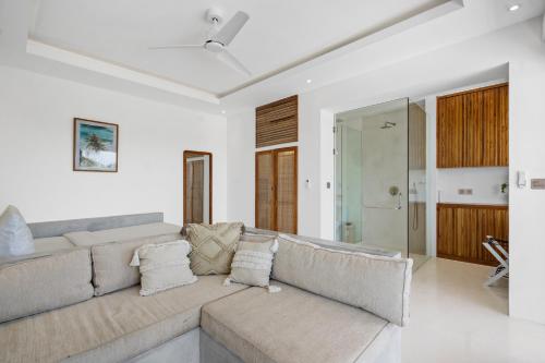 a living room with a large couch in a house at Pagi Villas by Betterplace in Canggu