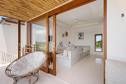 a living room with a couch and a chair at Pagi Villas by Betterplace in Canggu