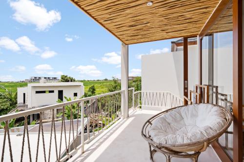 a balcony with a chair and a view at Pagi Villas by Betterplace in Canggu