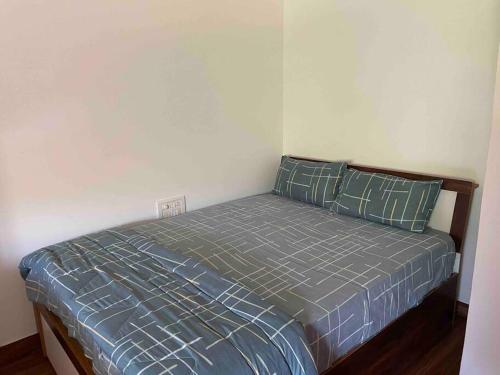 a bedroom with a bed with blue comforter and pillows at Studio apartment in Cancaona in Canacona