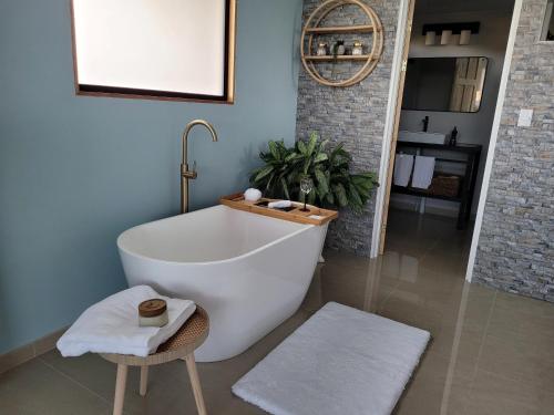 baño con bañera blanca y taburete en Azulita Oasis, en Aguas Zarcas
