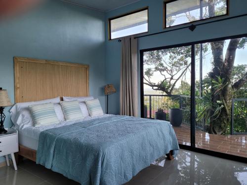 een slaapkamer met een bed en een groot raam bij Azulita Oasis in Aguas Zarcas