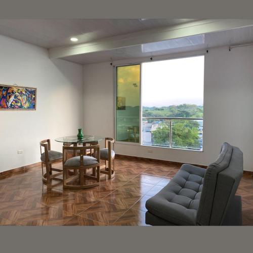 sala de estar con mesa y sofá en Apartamentos Amoblados Napoles en Doradal