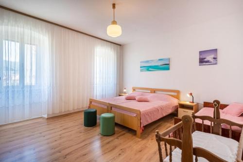 a bedroom with a bed and a table and chairs at Apartments Mici 1 - great location and relaxing in Cres
