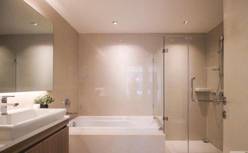 bagno con vasca, doccia e lavandino di BTS Thonglor New 2 bedrooms condo a Bangkok