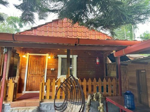 a wooden house with a bench in front of it at Oxyzone Coorg by StayApart in Madikeri