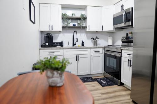 a kitchen with white cabinets and a wooden table at Jay's Cozy Escape in Tampa