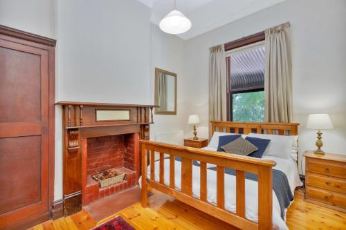 a bedroom with a bed and a fireplace at Barossa Vineyard Guesthouse in Tanunda