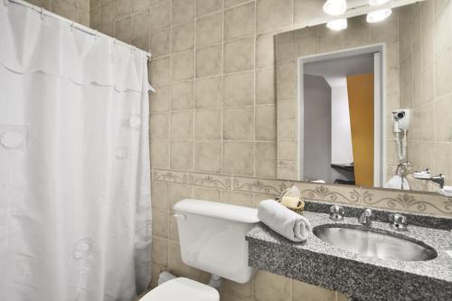 y baño con lavabo, aseo y espejo. en Hotel Milan en Buenos Aires