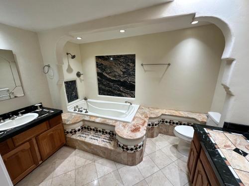 a bathroom with a tub and a sink and a toilet at One Bedroom Apartment at Rancho Rillito in Tucson