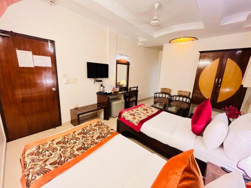 a hotel room with two beds and a television at Paras Inn in New Delhi
