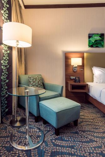 a hotel room with a bed and a chair and a table at Hilton Garden Inn Astana in Astana