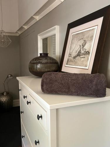 a white dresser with a vase on top of it at MURRUMBURRAH ARTHOUSE APARTMENTS in Harden