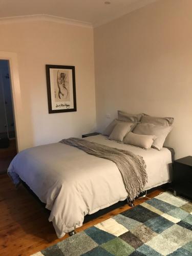 1 dormitorio con 1 cama grande con manta en MURRUMBURRAH ARTHOUSE APARTMENTS, en Harden