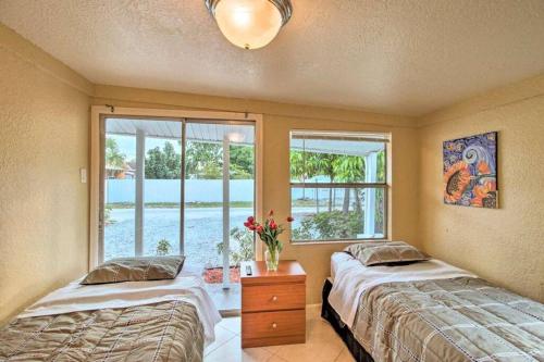 two beds in a room with a window at Palm Wave Stays - Central and Cozy Apt in West Palm Beach
