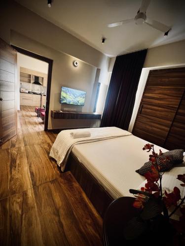 1 dormitorio con 1 cama grande y TV de pantalla plana en King Suite Luxury 74 sqm en Madurai